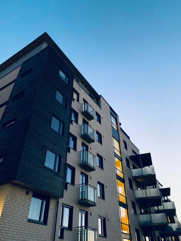 Fachada de un bloque de viviendas con balcones, vista desde la calle al atardecer
